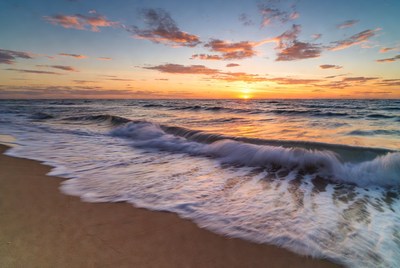 Sunset over ocean waves at beach