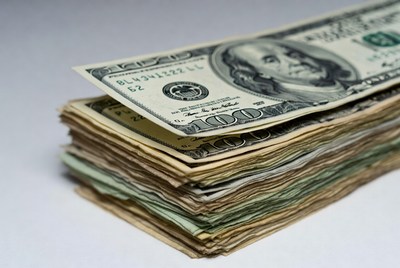 Stacked hundred dollar bills on table