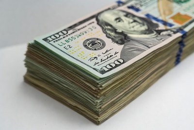 Stack of hundred dollar bills on surface