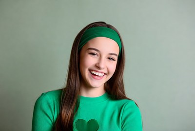 Girl in green smiles brightly