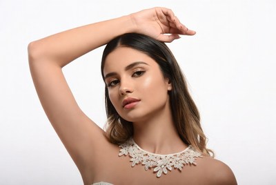 Model posing with raised arm indoors