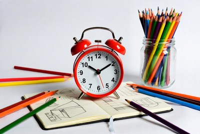 Clock and colorful pencils on a desk