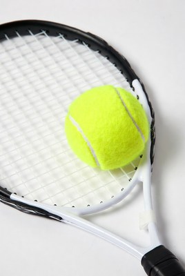 Tennis ball rests on racket