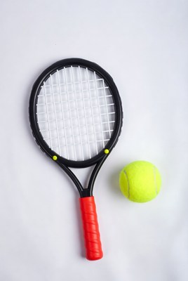 Tennis racket and yellow ball on surface