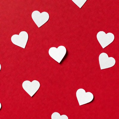Hearts scattered on red background