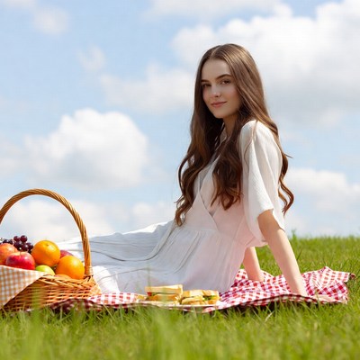 Picnic scene in green field with woman