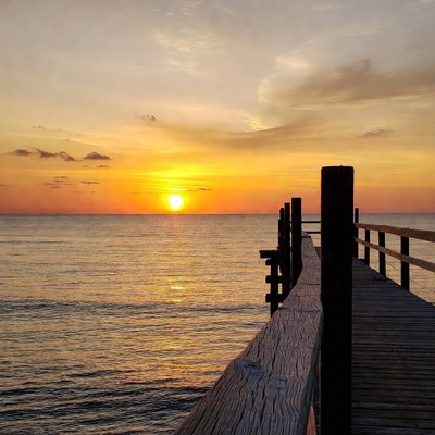 Sunset over water and pier