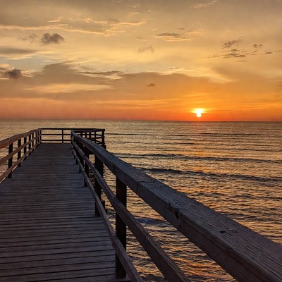 Sunset view from wooden pier over ocean