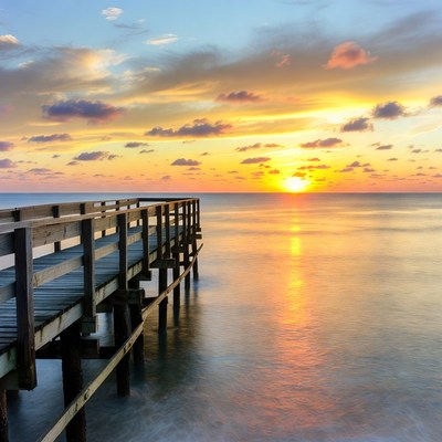 Sunset over a wooden pier by the sea