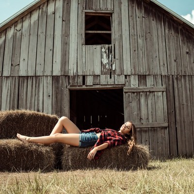 Young woman rests on hay bales