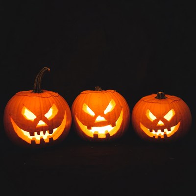 Three glowing pumpkins on halloween