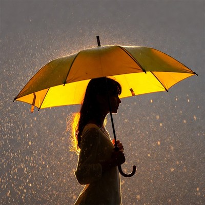 Woman holding yellow umbrella in rain