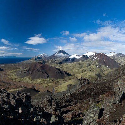 Snow-capped volcanoes in green valley
