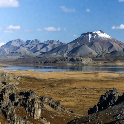 Snow-capped volcano and lake in mountains