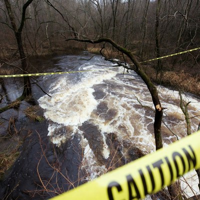 Caution Tape Over Rushing Forest River