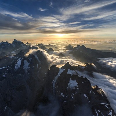 Snowy Mountains at Sunrise Above Clouds