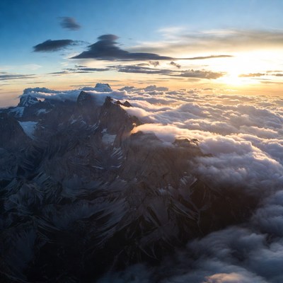 Snowy Mountains Above Clouds at Sunset