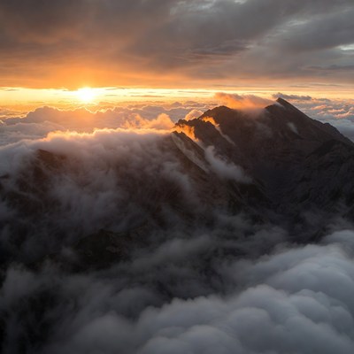Sunrise Over Mountain Peaks in Clouds