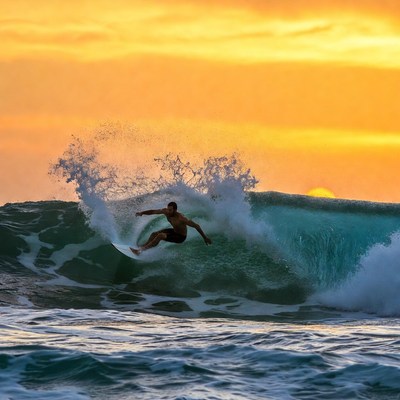 Man surfing massive wave at sunset
