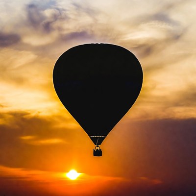 Black hot air balloon at sunset