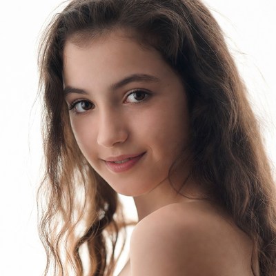 Young girl with wavy brown hair smiling
