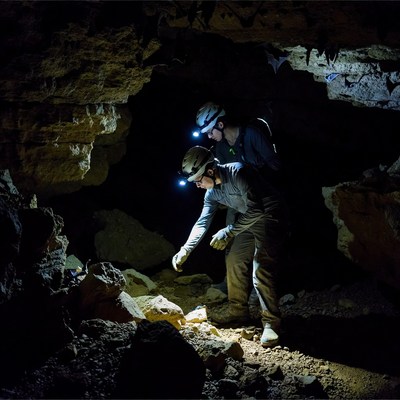 Two men caving in dark cave