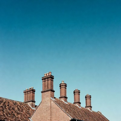 Brick Chimneys on Rooftop Against Blue Sky