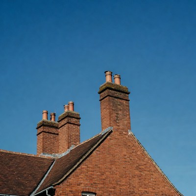 Brick Chimneys on Rooftop Against Blue Sky