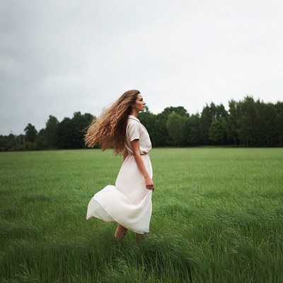 Woman in white dress in green field