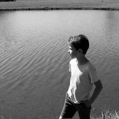 Boy standing by lake