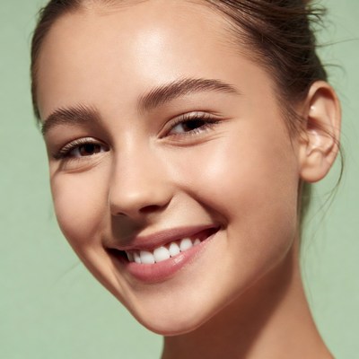 Smiling young woman on green background