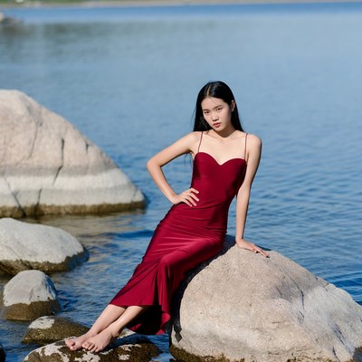 Asian woman in red dress by lake