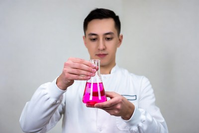 Asian man holding pink liquid flask