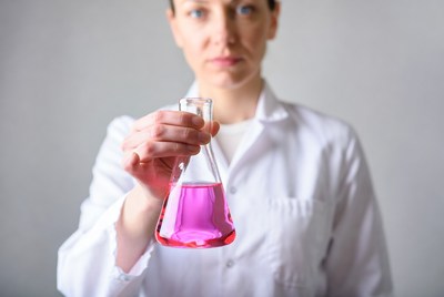 Woman holding pink liquid flask