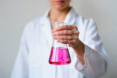 Woman holding pink liquid flask