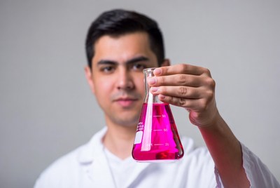 Man holding pink liquid flask