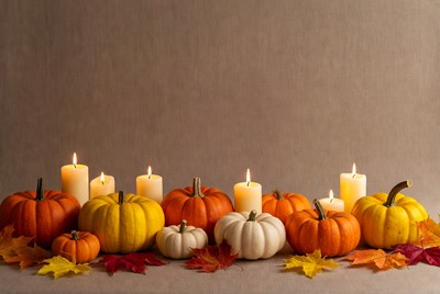 Pumpkins and Candles on Autumn Leaves