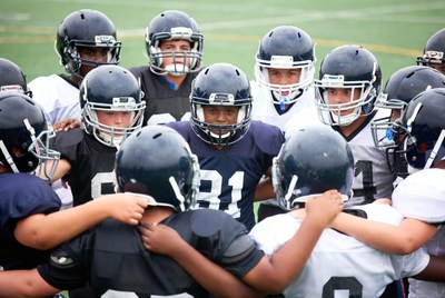 Football team huddle on field