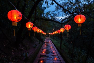 Red lanterns hanging over stone path