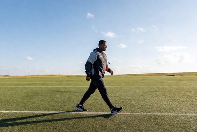 African-American man walking on soccer field