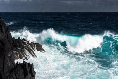 Waves crashing on black rocks