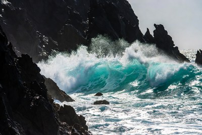 Turquoise waves crashing on rocks