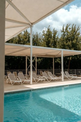 Empty Lounge Chairs Poolside Under Canopy