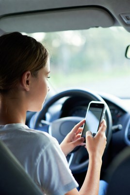 Woman driving while using phone