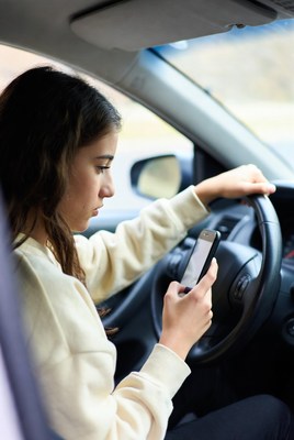 Woman driving car texting phone