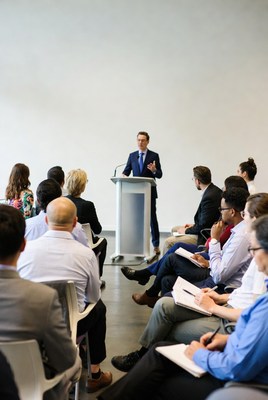 Man speaking at podium to audience