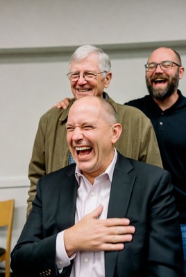 Three men laughing together