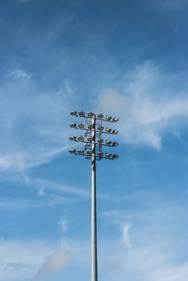 Tall Floodlight Tower Against Blue Sky