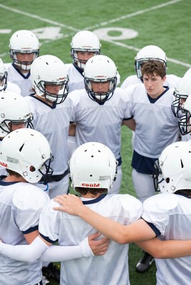 Football team huddle on field