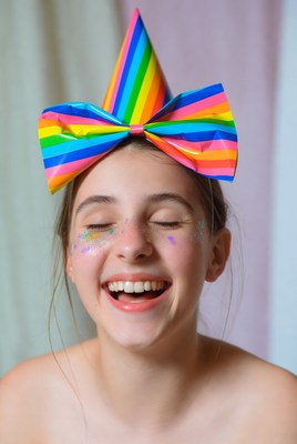 Girl laughing in rainbow party hat